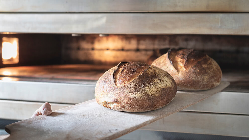 Carls Hofbäckerei - Brot wird aus dem Ofen geholt